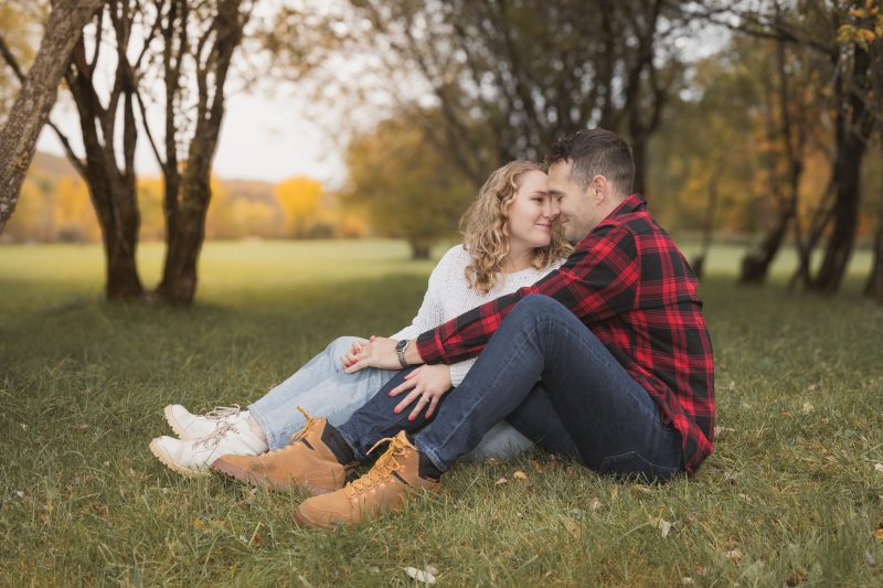 Jeune couple amoureux assis dans un décor d'automne