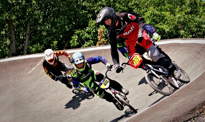 Trois jeunes hommes en pleine course de BMX