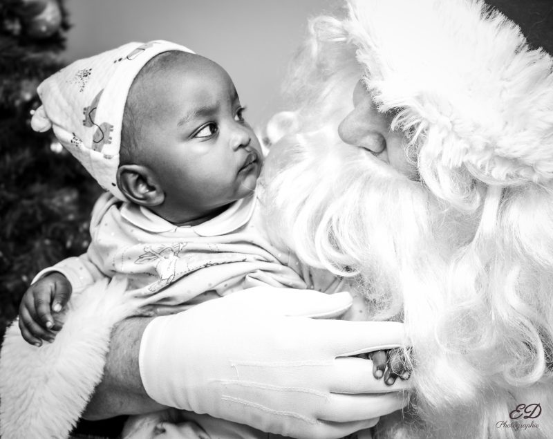 Père Noël tenant un enfant dans ses bras