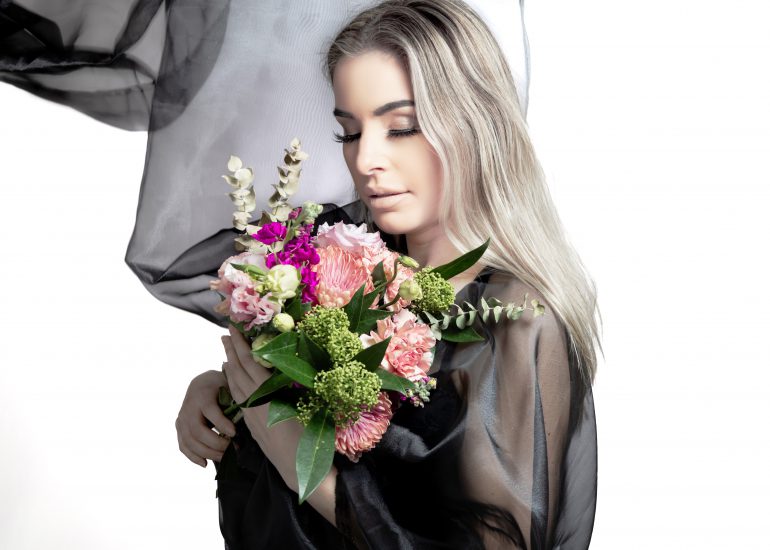 Jeune femme tenant bouquet de fleurs