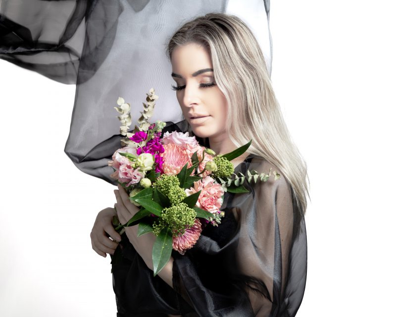 Jeune femme tenant bouquet de fleurs